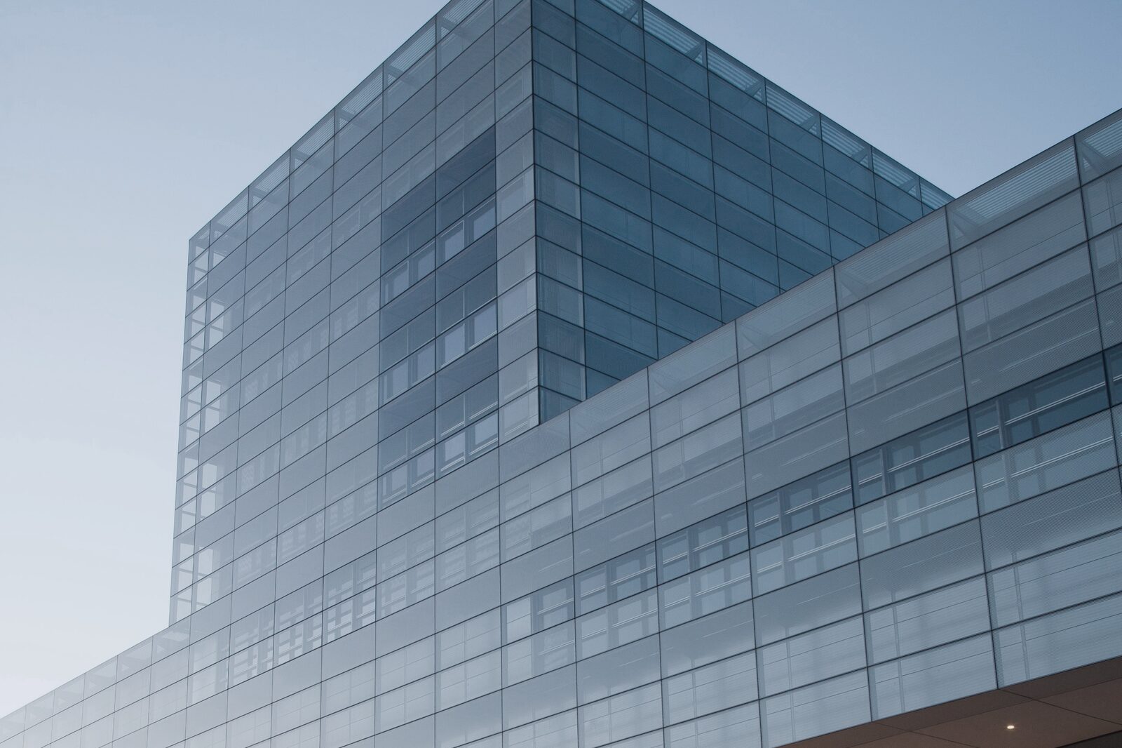 Moderne Glasfassade eines Bürogebäudes vor klarem Himmel